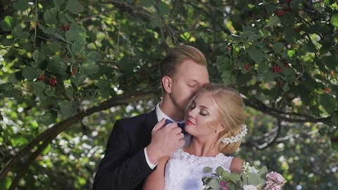 The bride and groom walking in the Park in the summer. kiss and hug Vidéo 81481748