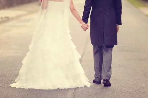 Bride and groom walking on road Stock Photos