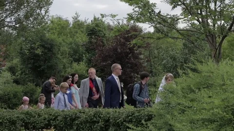 The bride and guests walk through the summer garden Video stock 77627279