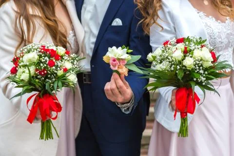 The bride and two brides hold their wedding bouquets, showing them. Foto stock