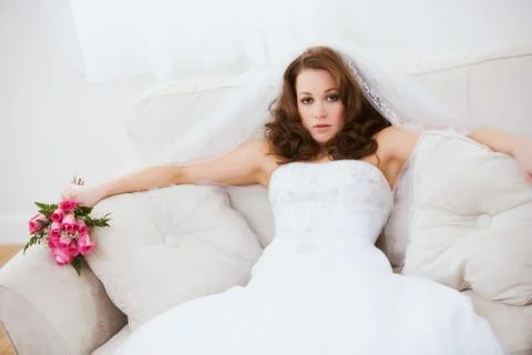 Bride: Annoyed Bride Sits On Couch with Bouquet Stock Photos