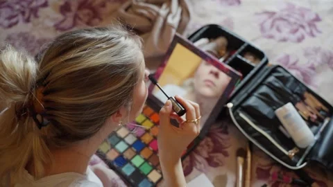 Bride applying makeup in front of a mirror while getting ready for her wedding Stock Footage 312248594