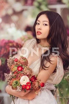 Bride. Asian female with wedding bouquet Stock Photos