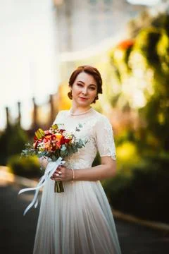 Bride on a background of trees in the park. Stock Photos