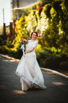 Bride on a background of trees in the park. Stock Photos