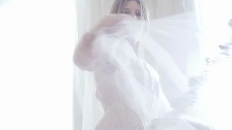 The Bride in a Bathrobe Dancing by the Window. Veil develops Stock Footage 123513958