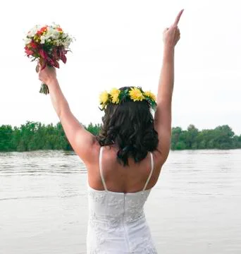 The bride from behind is looking to the other side of the river with both hands Foto stock