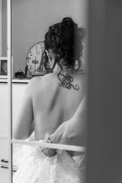A bride from behind, reflected in a mirror, is wearing a wedding dress Stock Photos