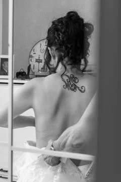 A bride from behind, reflected in a mirror, is wearing a wedding dress Stock Photos