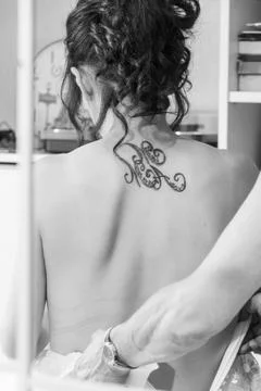 A bride from behind, reflected in a mirror, is wearing a wedding dress Stock Photos