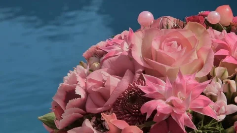 Bride bouquet is lying on sun deck blue swimming pool Stock Footage 75830124