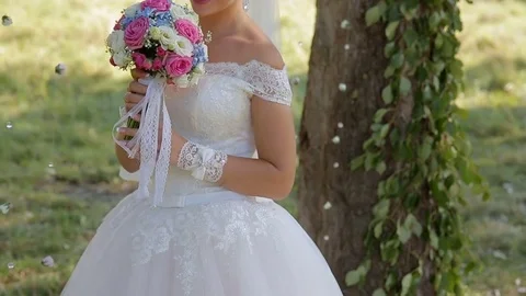 Bride with a bouquet in the park Stock Footage 77187964