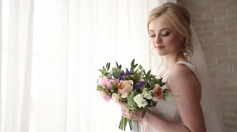 Bride with a bouquet at a window Видео 60386006