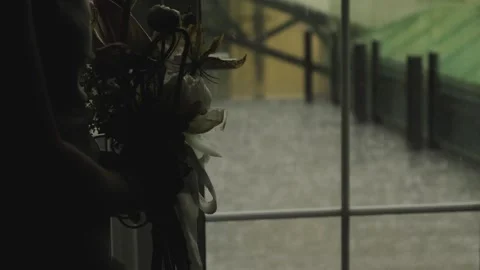 Bride closeup with bouquet by window, soft backlight through rainstreaked glass Stock Footage 323392661