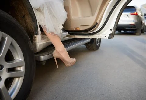 Bride comes out from the car close Stock Photos