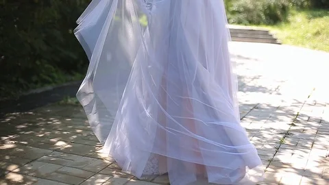 The bride dancing the park on her wedding day in a white dress with a train Stock Footage 82584690