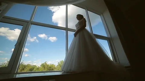 Bride in the dress of the big window against the sky Stock Footage