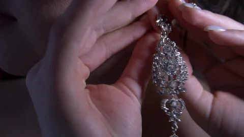 Bride dresses earrings at a wedding Stock Footage 127686687