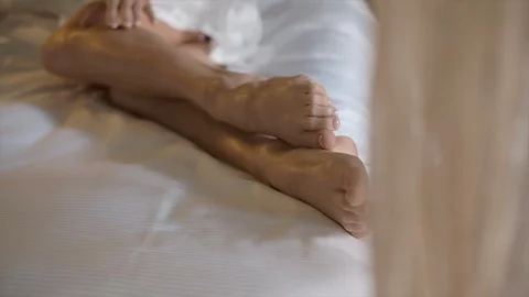 Bride Drinking Champagne In Bed. Legs Close Up. Video stock 106093667