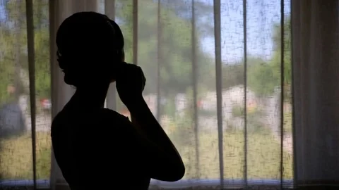 Bride earring near the window Stock Footage 70382962