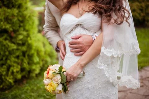 The bride embraces the bride in the background of greenery Stock Photos