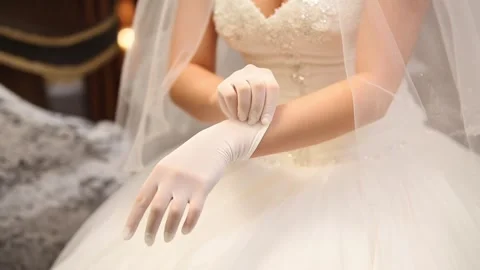A bride gently putting on delicate white gloves before her Video stock 319547273