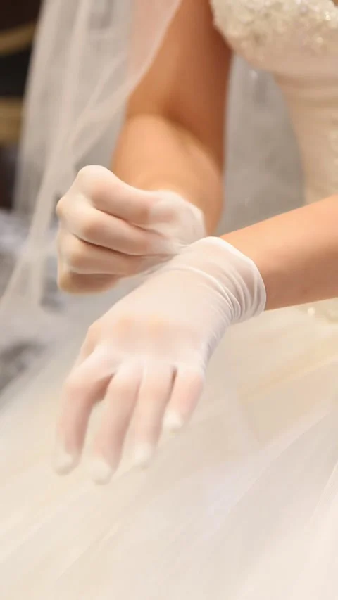 A bride gently putting on delicate white gloves before her vertical Stock Footage 319547274