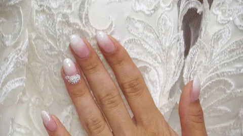 The bride gently runs her hand over the bride's dress Stock Footage 127951542