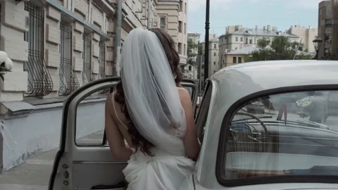 Bride gets into an old classic car Stock Footage 137581463