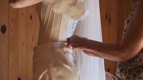 A bride gets ready for her special day as a friend helps with her wedding dress Stock Footage 317394565