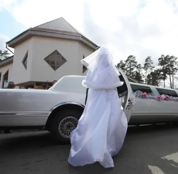The bride getting on limousine Stock Photos