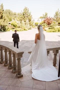 The bride goes down the stairs to the first meeting with the groom. Stock Photos