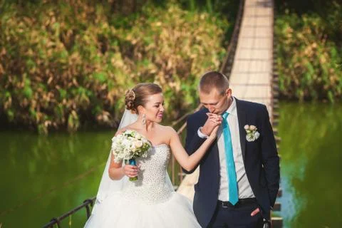 Bride with groom on the bridge in forest Stock Photos