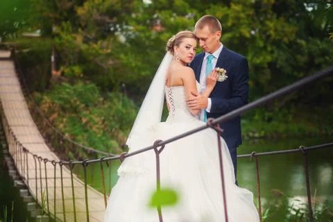 Bride with groom on the bridge in forest Stock Photos