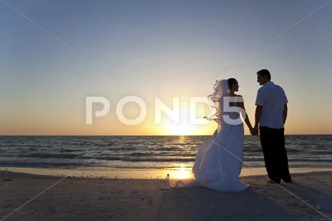 Bride & groom married couple sunset beach wedding Stock-Fotos