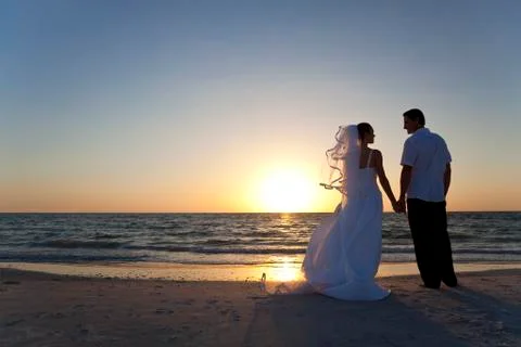Bride & groom married couple sunset beach wedding Stock Photos