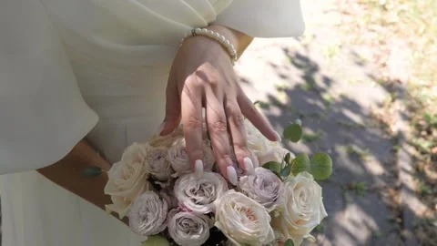Bride hand with pearl bracelet touching luxury wedding bouque Video stock 331859880