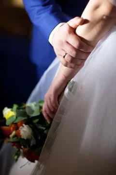Bride hands with ring and wedding bouquet of flowers Stock Photos
