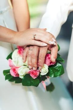 Bride hands with ring and wedding bouquet of flowers Stock Photos