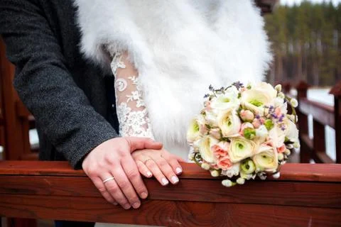 Bride hands with ring and wedding bouquet of flowers Stock Photos