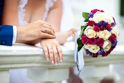 Bride hands with ring and wedding bouquet of flowers Stock Photos