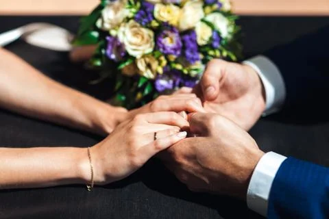Bride hands with ring and wedding bouquet of flowers Stock Photos