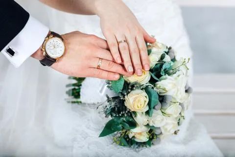 Bride hands with ring and wedding bouquet of flowers Stock Photos