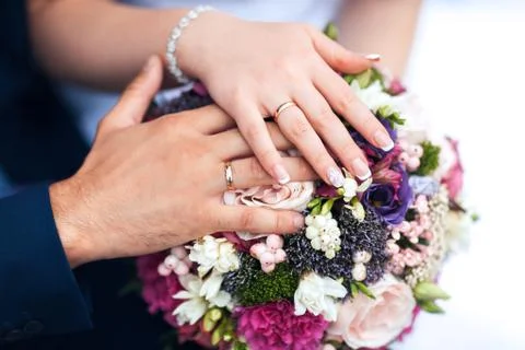 Bride hands with ring and wedding bouquet of flowers Stock Photos