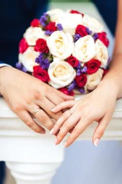 Bride hands with ring and wedding bouquet of flowers Stock Photos
