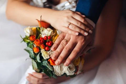 Bride hands with ring and wedding bouquet of flowers Stock Photos