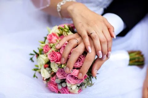 Bride hands with ring and wedding bouquet of flowers Stock Photos