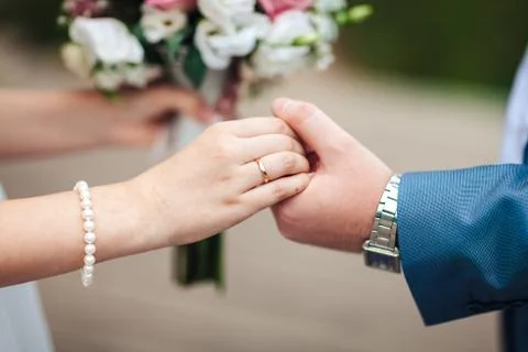 Bride hands with ring and wedding bouquet of flowers, Newlyweds hold hands,.. Stock Photos