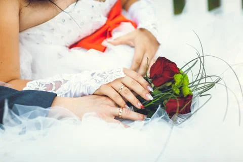Bride hands with ring and wedding bouquet of flowers Stock Photos