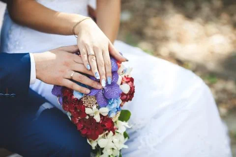 Bride hands with ring and wedding bouquet of flowers Stock Photos